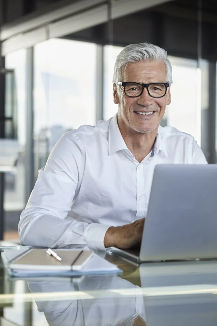 A founder working at a laptop in a glass-walled office