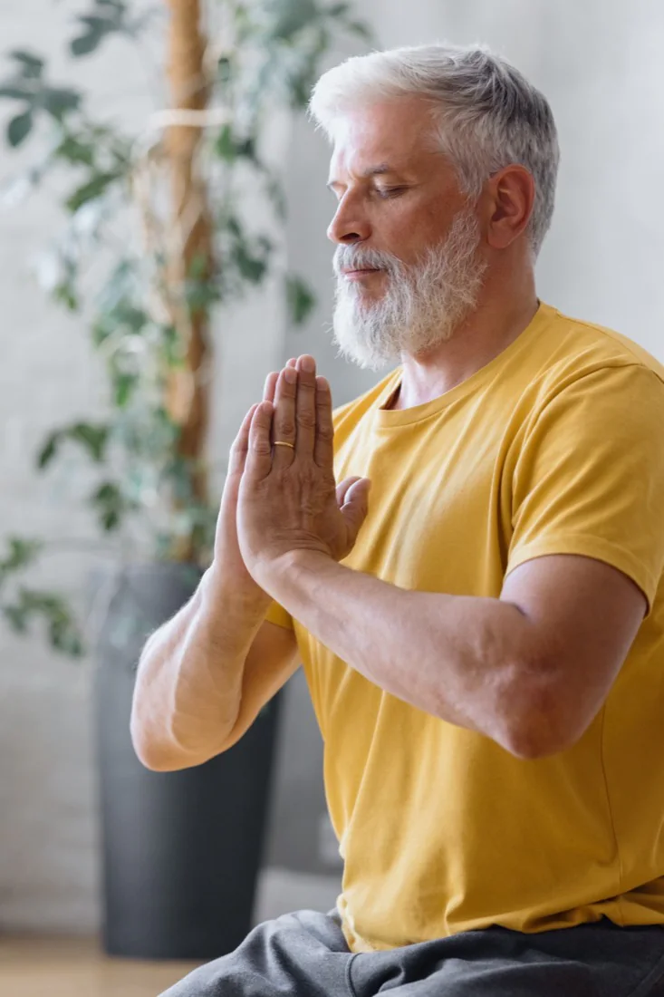 A mature man meditating at home in a peaceful setting